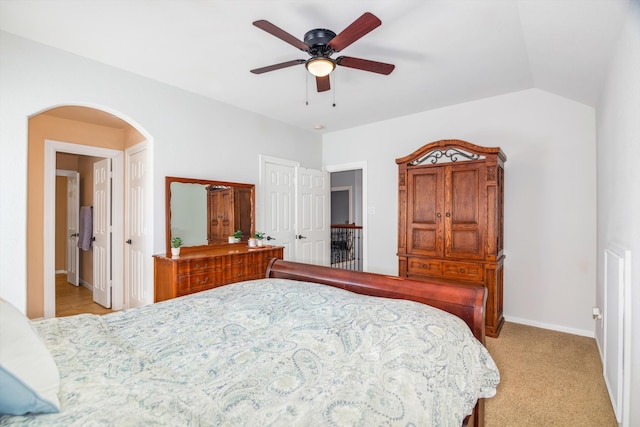 bedroom with ceiling fan, light colored carpet, and vaulted ceiling