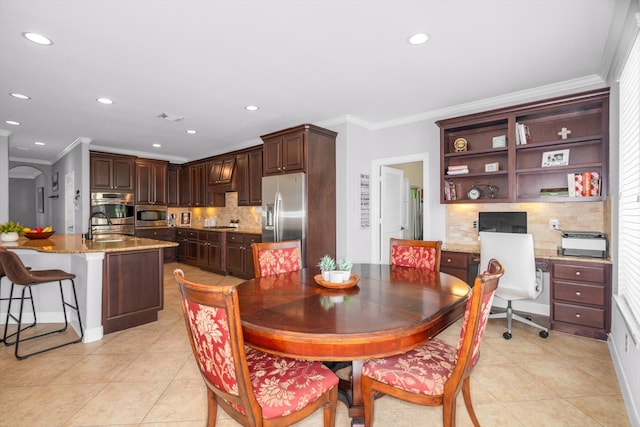 tiled dining space featuring ornamental molding and sink