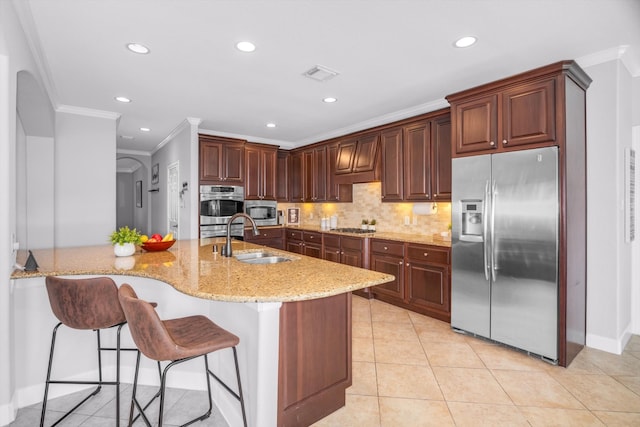 kitchen with sink, stainless steel appliances, backsplash, a kitchen bar, and ornamental molding