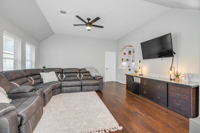 living room featuring built in shelves, ceiling fan, dark wood-type flooring, and lofted ceiling