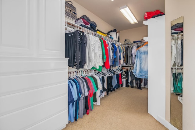 walk in closet featuring light carpet