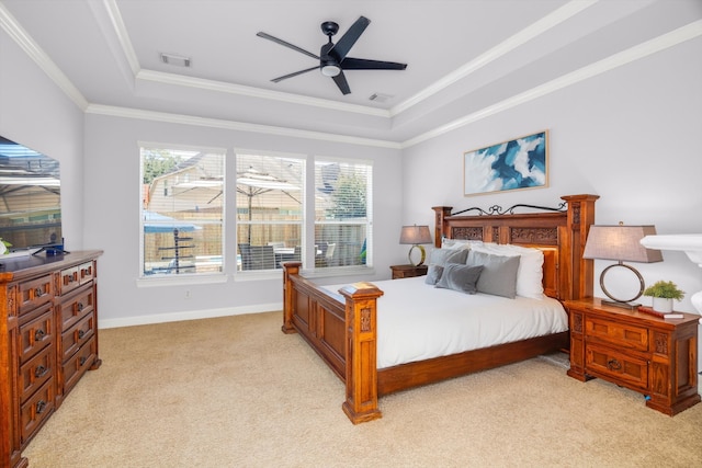 carpeted bedroom with ceiling fan, crown molding, and a tray ceiling