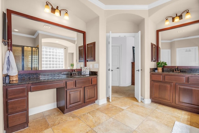 bathroom featuring crown molding, a shower with door, and vanity