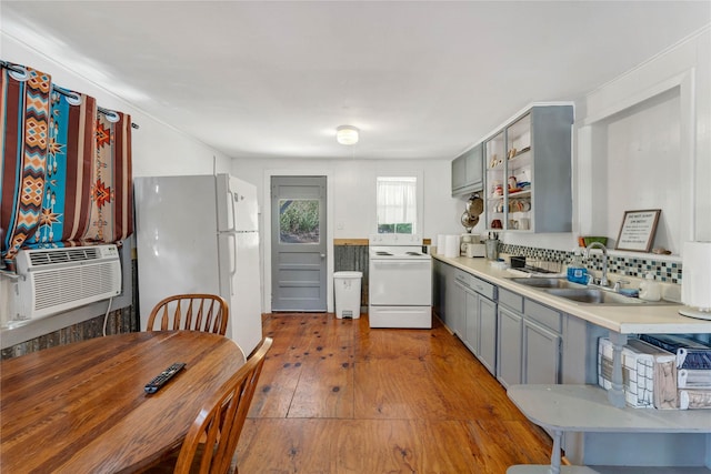 kitchen with backsplash, sink, white appliances, light hardwood / wood-style flooring, and gray cabinetry