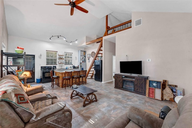 living room featuring ceiling fan, high vaulted ceiling, and a fireplace