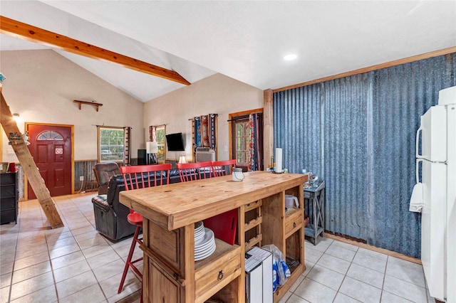 kitchen with vaulted ceiling with beams, light tile patterned floors, wooden walls, and white fridge