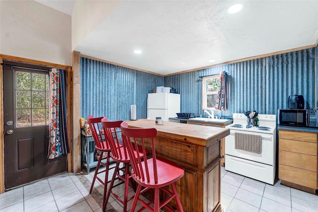 kitchen featuring light tile patterned floors and white appliances