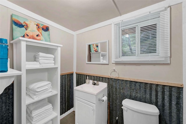 bathroom featuring toilet, vanity, and crown molding