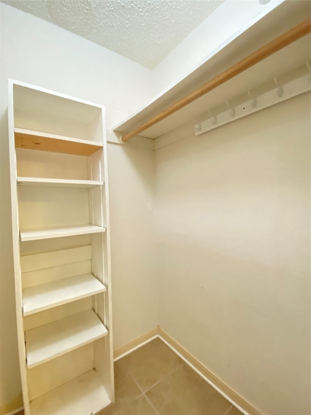 spacious closet with tile patterned floors