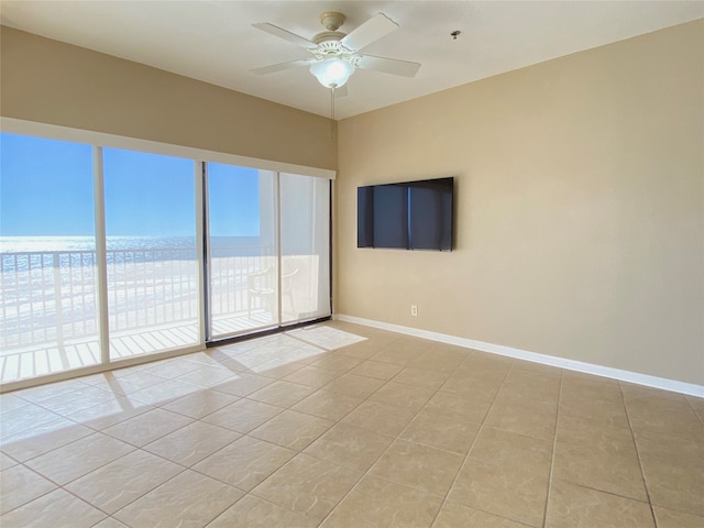 spare room with ceiling fan, a water view, and light tile patterned floors