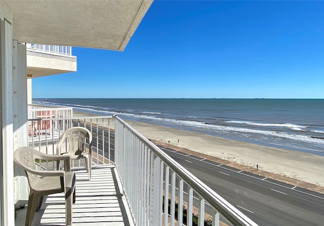 balcony with a water view and a beach view