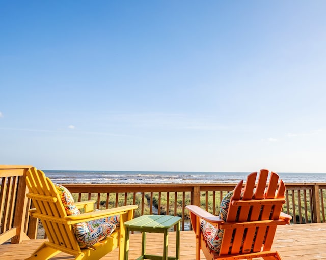 wooden terrace featuring a water view and a view of the beach