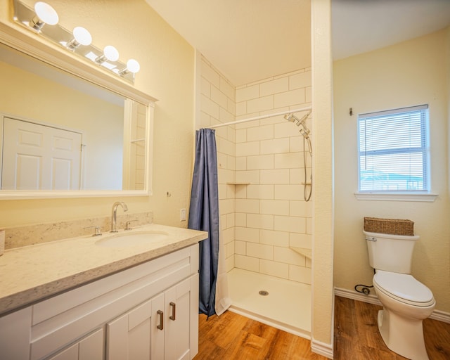 bathroom featuring walk in shower, vanity, toilet, and hardwood / wood-style floors