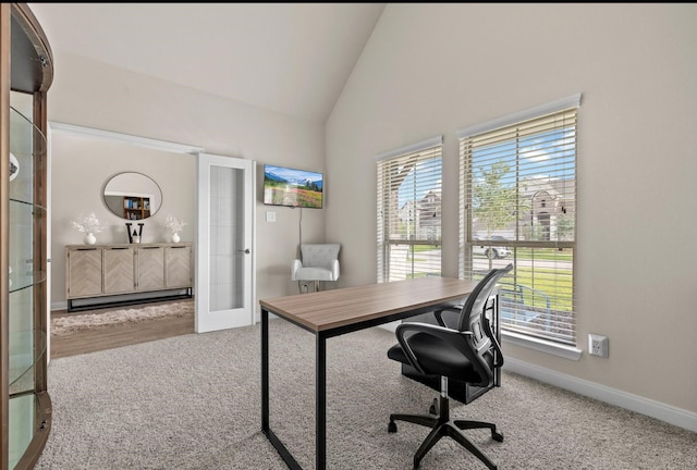 office with vaulted ceiling, light colored carpet, a baseboard radiator, and french doors