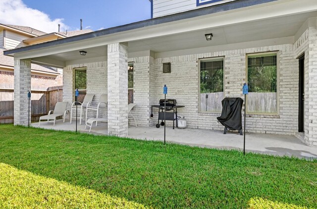 rear view of property with a lawn and a patio