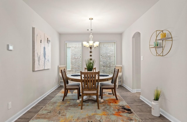 dining room with dark wood-type flooring and a chandelier