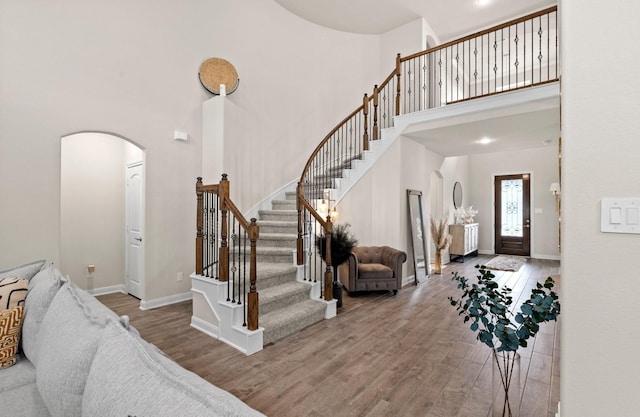 foyer entrance featuring a towering ceiling and hardwood / wood-style flooring