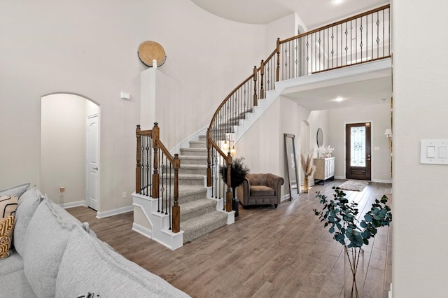 foyer entrance featuring wood-type flooring and a high ceiling