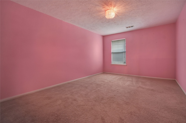 empty room featuring a textured ceiling and carpet floors