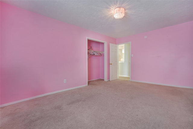 unfurnished bedroom with carpet flooring, a textured ceiling, and a closet