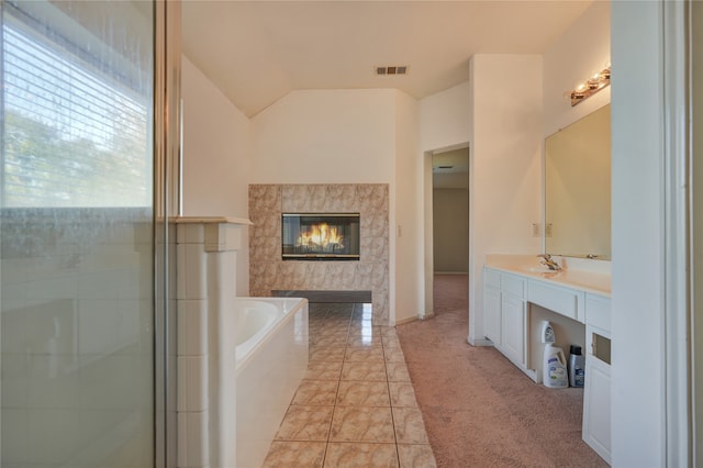 bathroom featuring tile patterned floors, vanity, separate shower and tub, and lofted ceiling