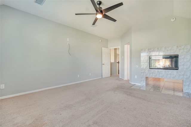 unfurnished living room with a tiled fireplace, light carpet, ceiling fan, and lofted ceiling