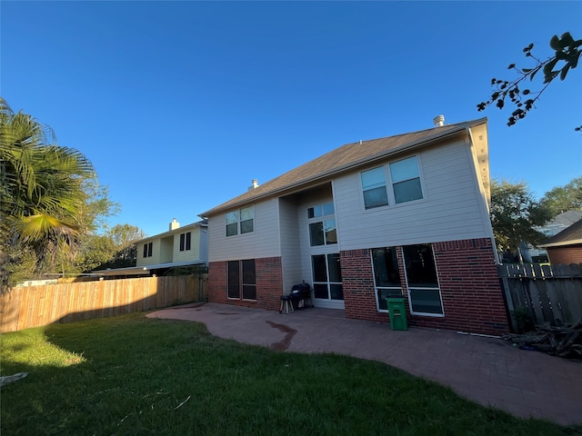 back of property featuring a yard and a patio