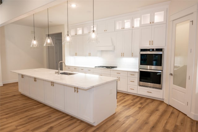 kitchen with white cabinets, appliances with stainless steel finishes, decorative light fixtures, and sink