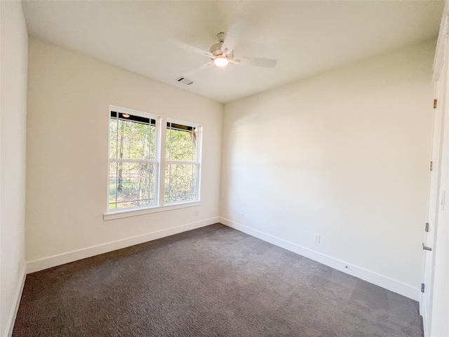 unfurnished room with dark colored carpet and ceiling fan