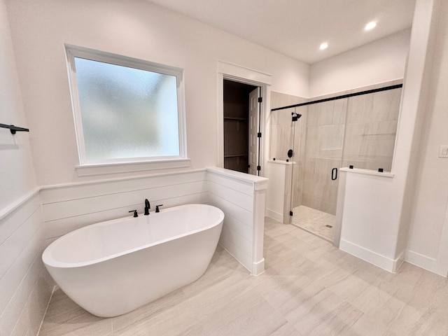 bathroom featuring shower with separate bathtub