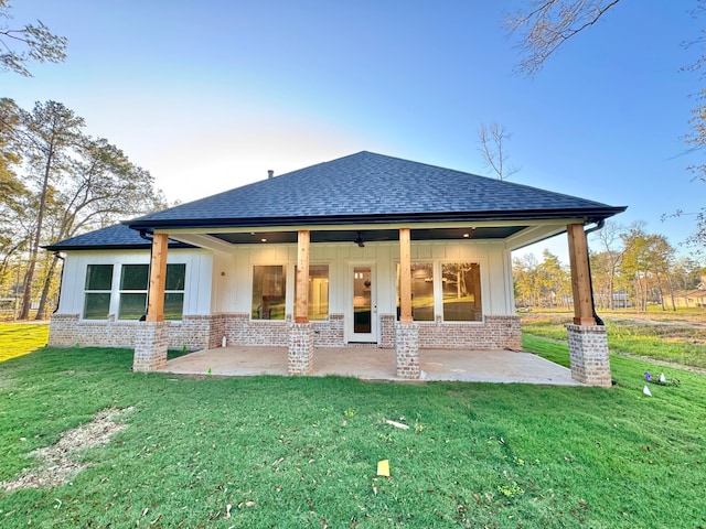 rear view of house featuring a patio area and a yard