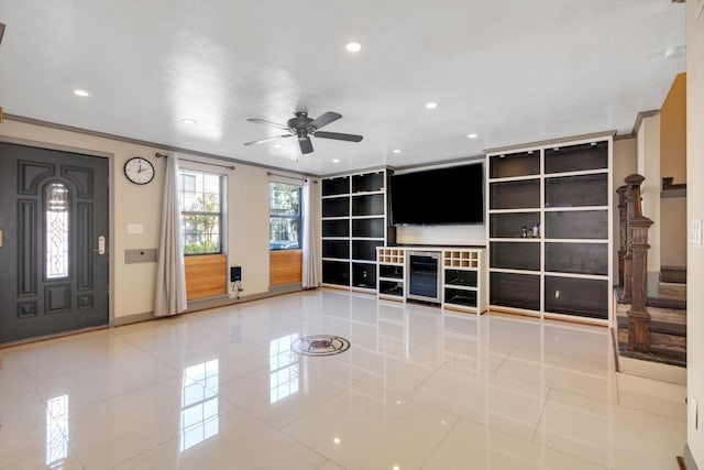 unfurnished living room featuring crown molding, light tile patterned floors, and ceiling fan