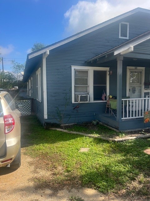 view of side of property featuring a yard and a porch