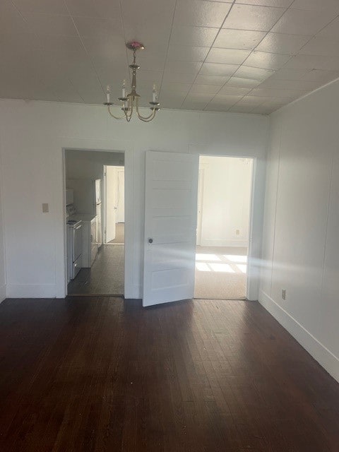 unfurnished room with dark hardwood / wood-style flooring and an inviting chandelier