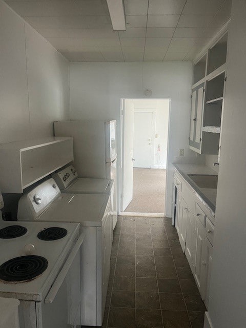 laundry area with dark tile patterned flooring and sink