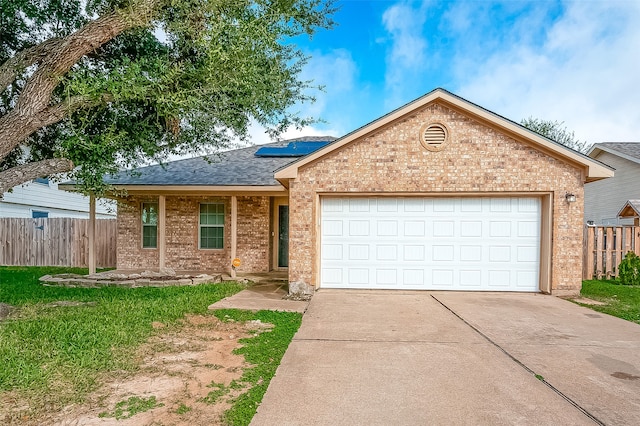 ranch-style home with a garage and solar panels