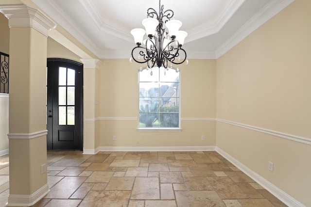 unfurnished dining area featuring a wealth of natural light, ornamental molding, a tray ceiling, and decorative columns