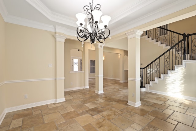 interior space with decorative columns, a raised ceiling, and ornamental molding