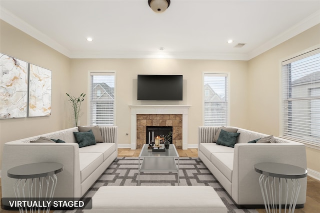 living room featuring a fireplace, a healthy amount of sunlight, and crown molding