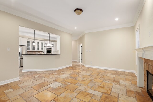 unfurnished living room featuring a tile fireplace and ornamental molding