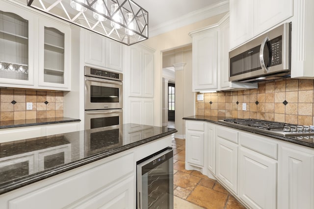 kitchen featuring stainless steel appliances, beverage cooler, white cabinets, tasteful backsplash, and decorative light fixtures