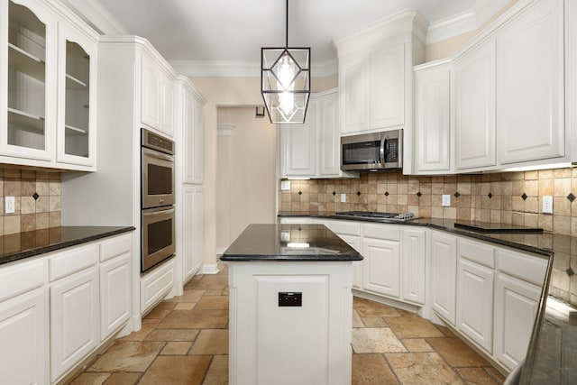 kitchen featuring stainless steel appliances, white cabinetry, ornamental molding, tasteful backsplash, and a center island