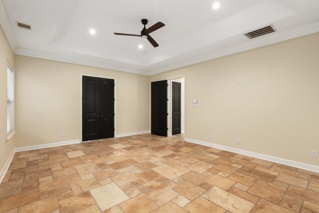 unfurnished bedroom featuring a raised ceiling, ceiling fan, and crown molding