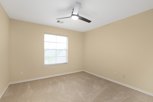 carpeted spare room with ceiling fan