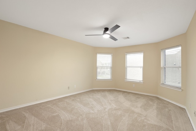 carpeted spare room featuring ceiling fan