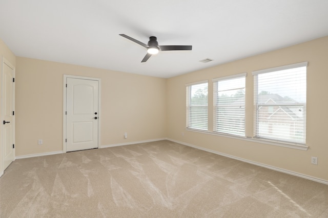 empty room featuring light colored carpet and ceiling fan