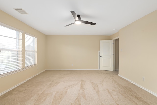 spare room featuring light carpet and ceiling fan