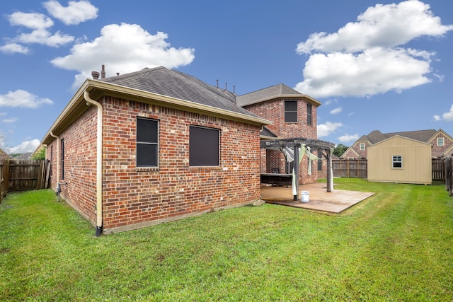 rear view of house with a lawn, a shed, a pergola, and a patio