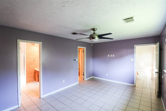 tiled spare room featuring ceiling fan and a textured ceiling