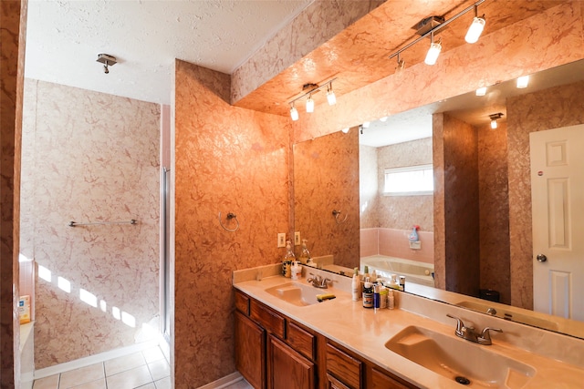 bathroom with tile patterned floors, a bathtub, a textured ceiling, and vanity